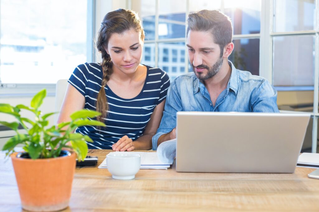 Partners calculating together with calculator in the office
