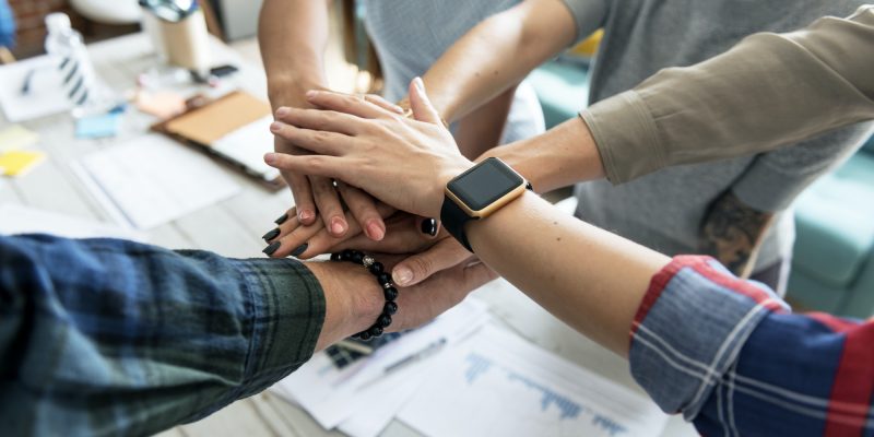 Co-workers stacking hands