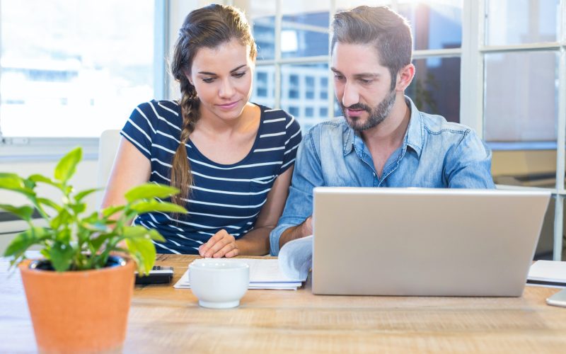Partners calculating together with calculator in the office